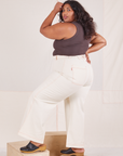 Angled back view of Bell Bottoms in Vintage Tee Off-White and espresso brown Tank Top worn by Morgan