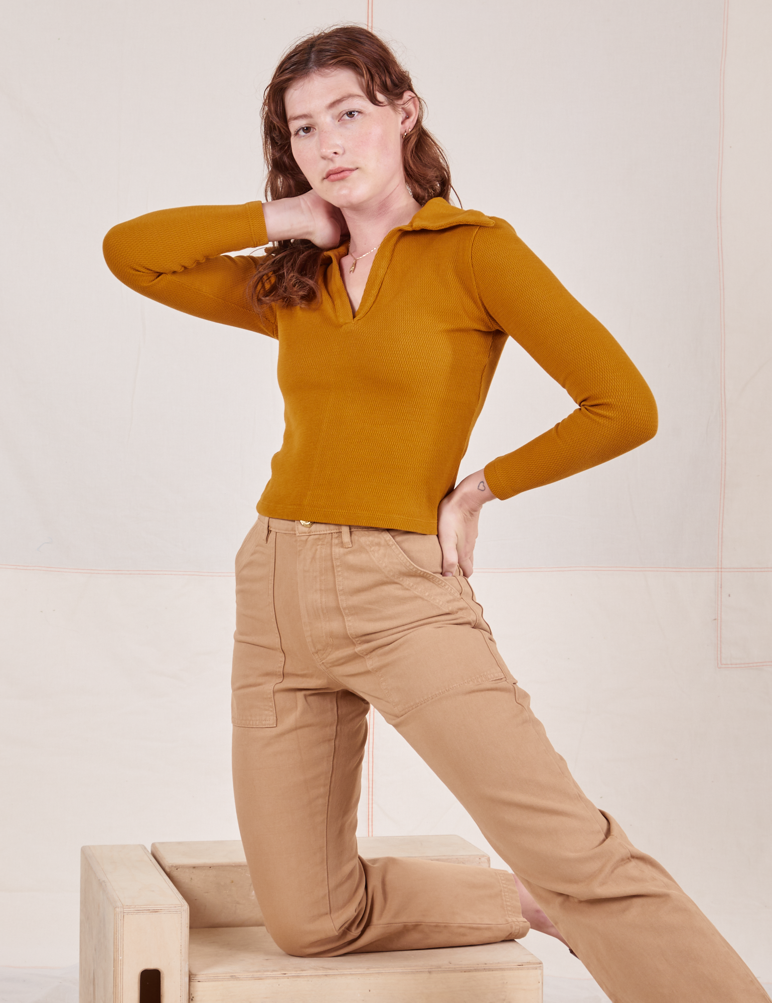 Alex is wearing Long Sleeve Fisherman Polo in Spicy Mustard and tan Work Pants