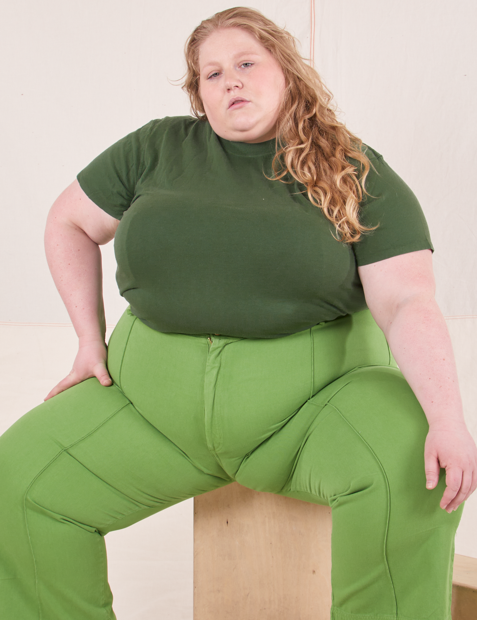 Catie is wearing Organic Vintage Tee in Dark Emerald Green and gross green Western Pants