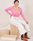 Wrap Top in Bubblegum Pink on Tiara wearing vintage tee off-white Western Pants sitting on wooden crate