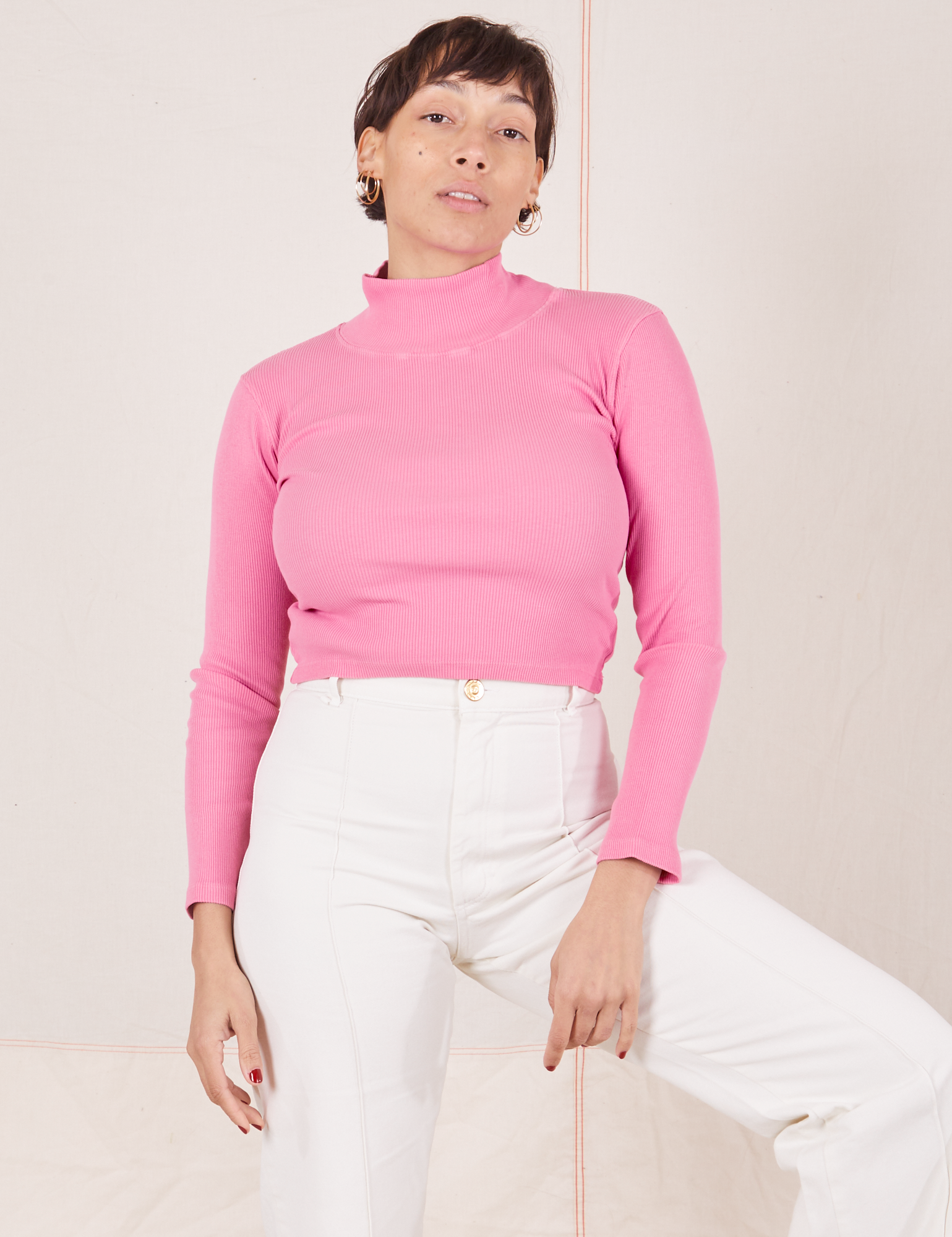 Tiara is wearing XS Essential Turtleneck in Bubblegum Pink paired with vintage tee off-white Western Pants