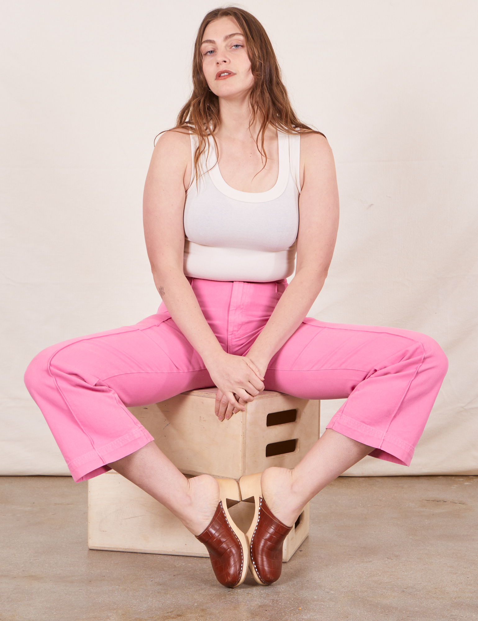 Western Pants in Bubblegum Pink on Allison wearing Tank Top in vintage tee off-white sitting on wooden crate
