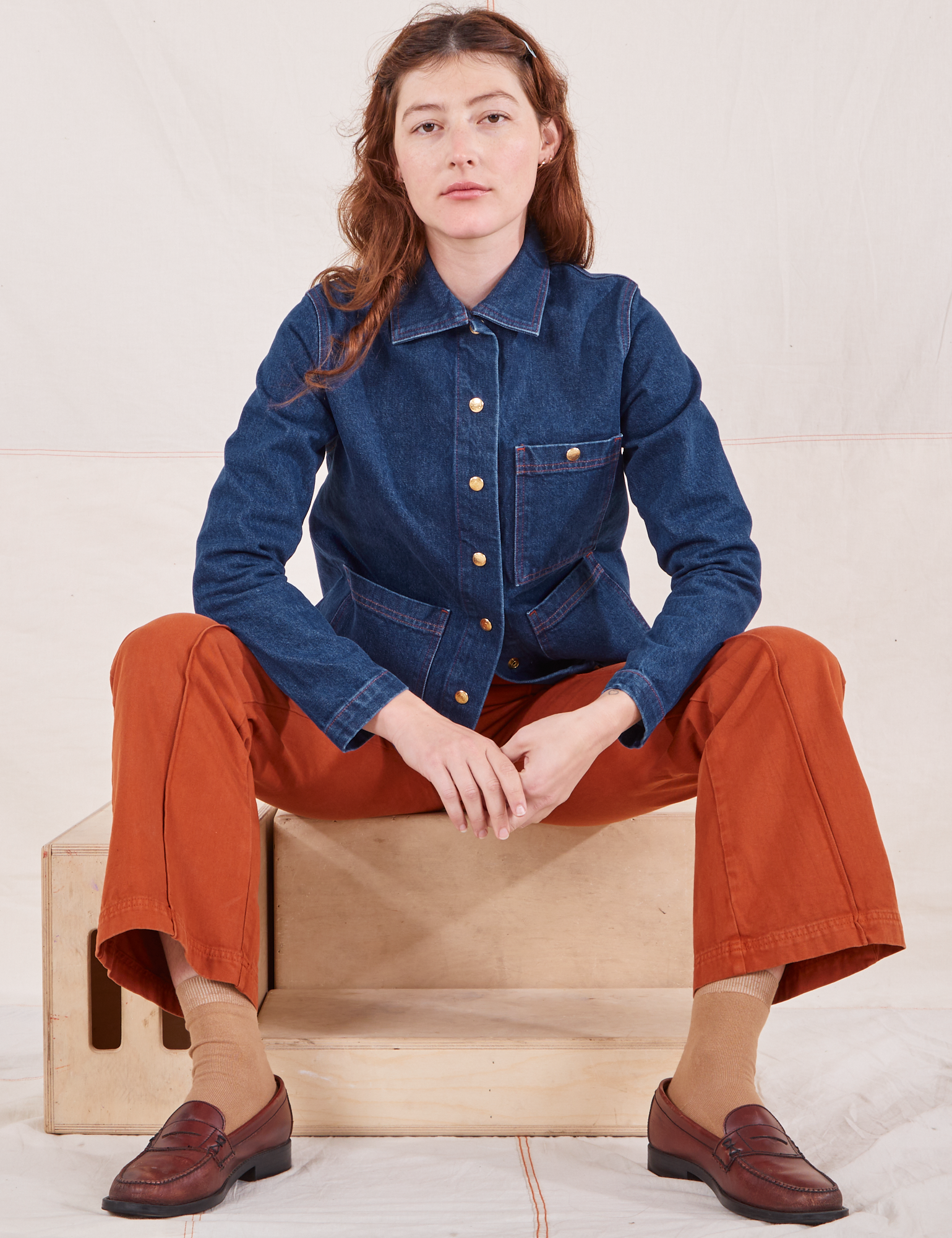 Alex is wearing Indigo Denim Work Jacket in Dark Wash and burnt terracotta Western Pants