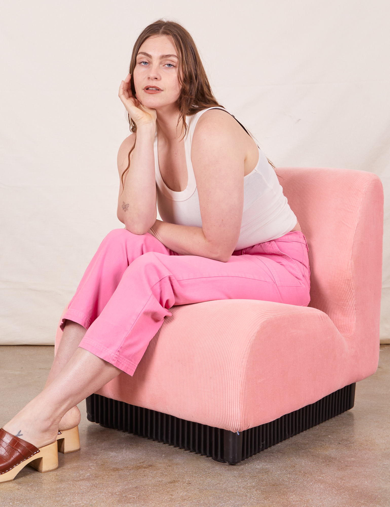 Work Pants in Bubblegum Pink on Allison wearing Tank Top in vintage tee off-white sitting in pink upholstered chair