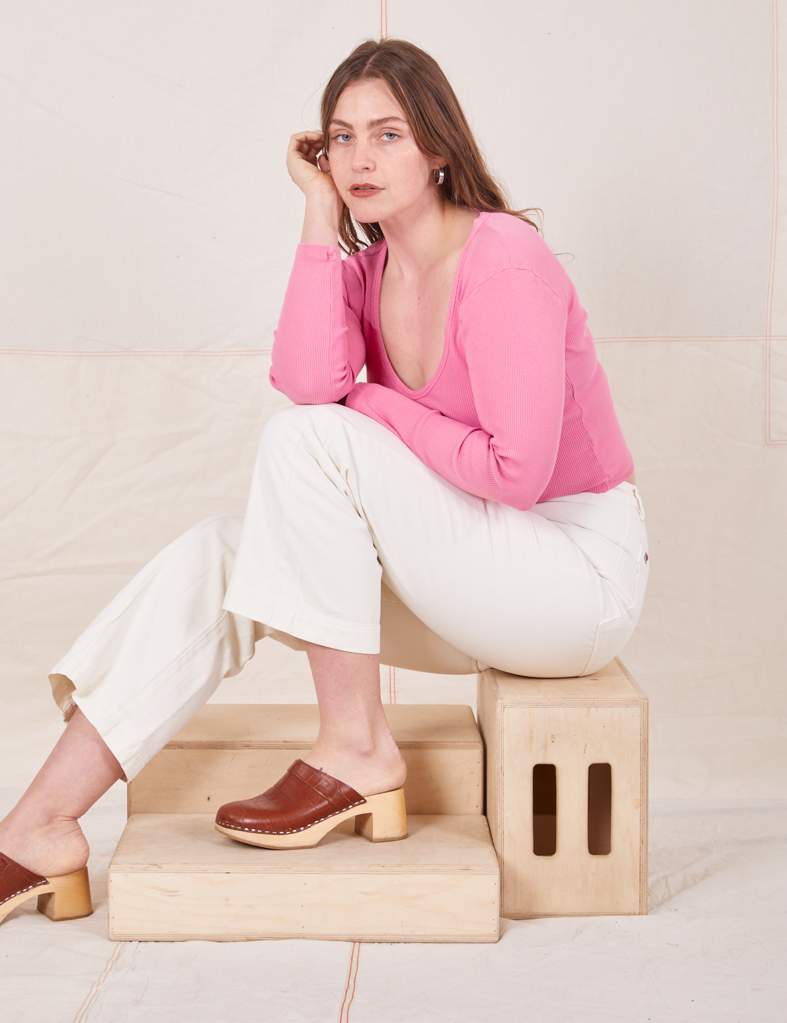  Long Sleeve V-Neck Tee in Bubblegum on Allison wearing vintage tee off-white Western Pants sitting on wooden crate