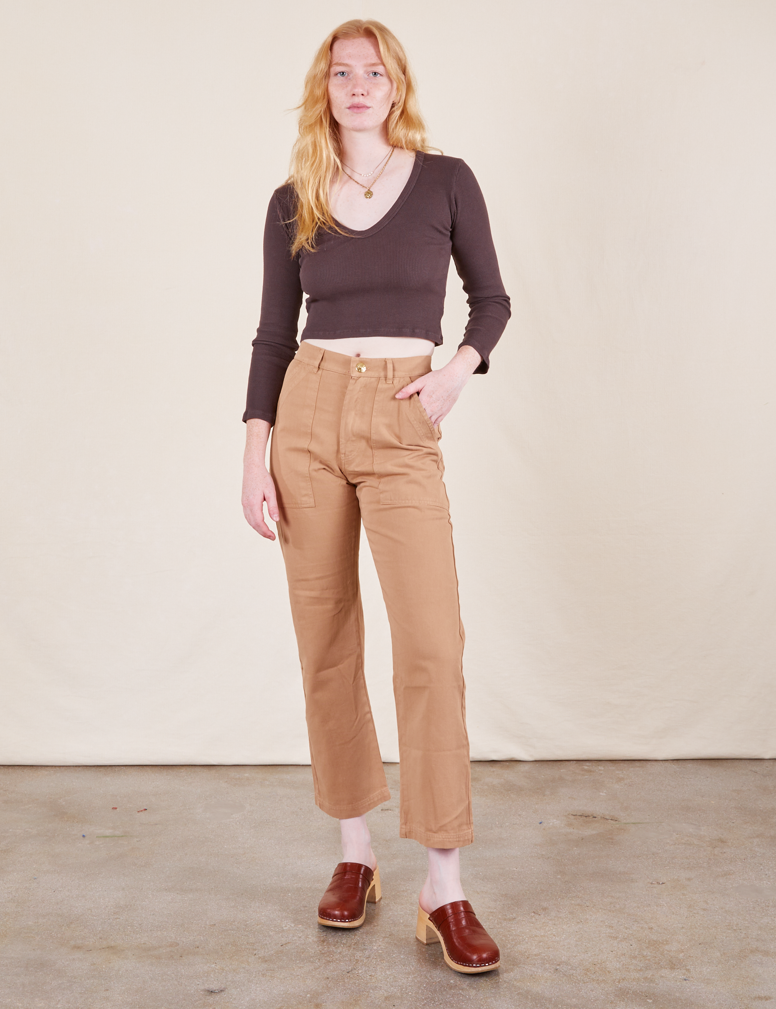 Margaret is 5&#39;11&quot; and wearing XXS Work Pants in Tan paired with espresso brown Long Sleeve V-Neck Tee