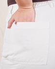 Work Pants in Vintage Tee Off-White back pocket close up. Faye has her hand in the pocket.