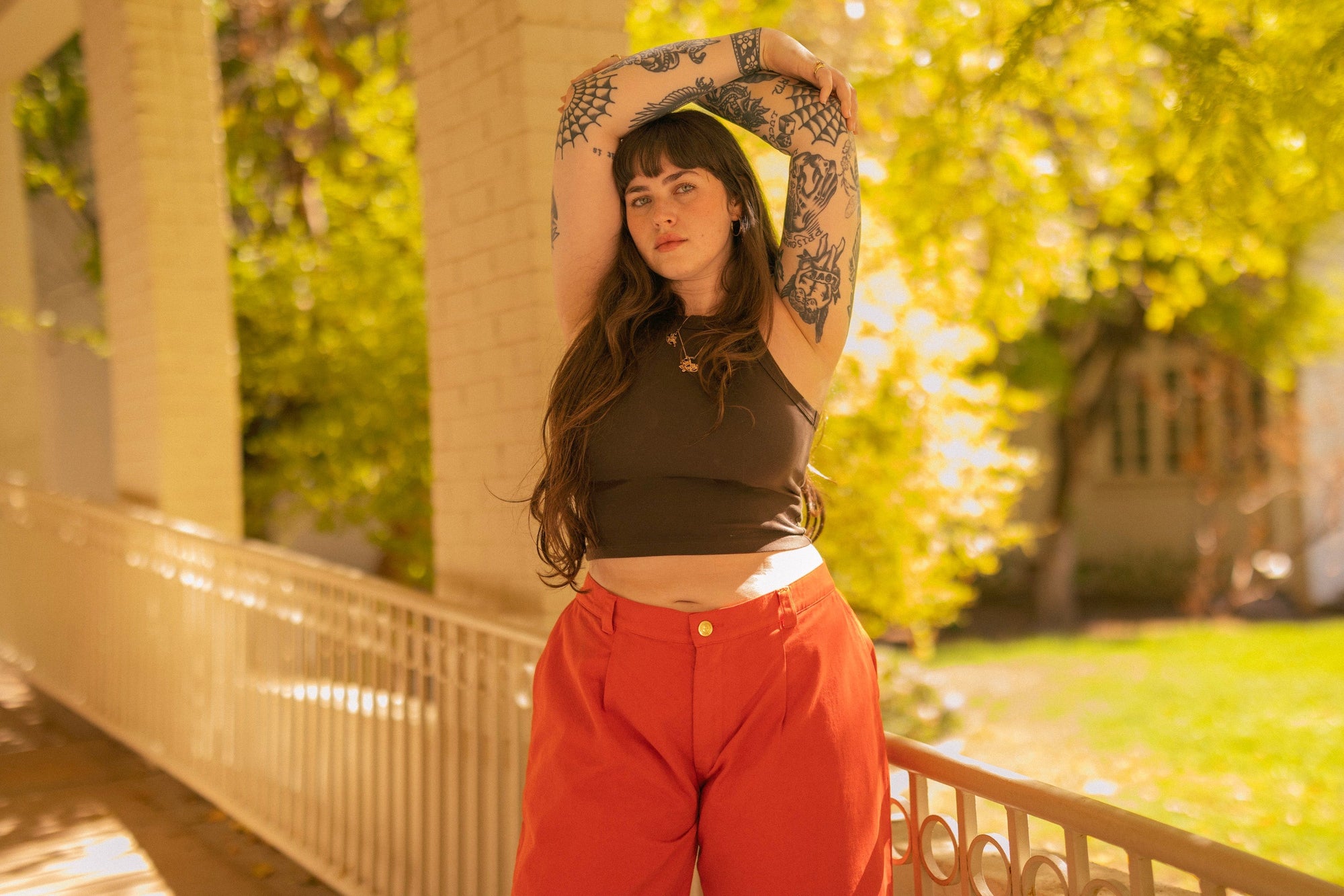 Sydney is wearing Mid-Rise Trousers in Chili Red paired with Racerback Tank in Espresso Brown