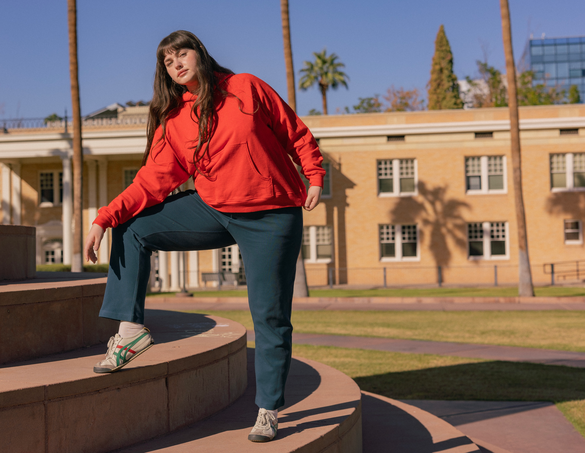 Sydney is wearing Oversized Hoodie in Mustang Red paired with Easy Pants in Lagoon.