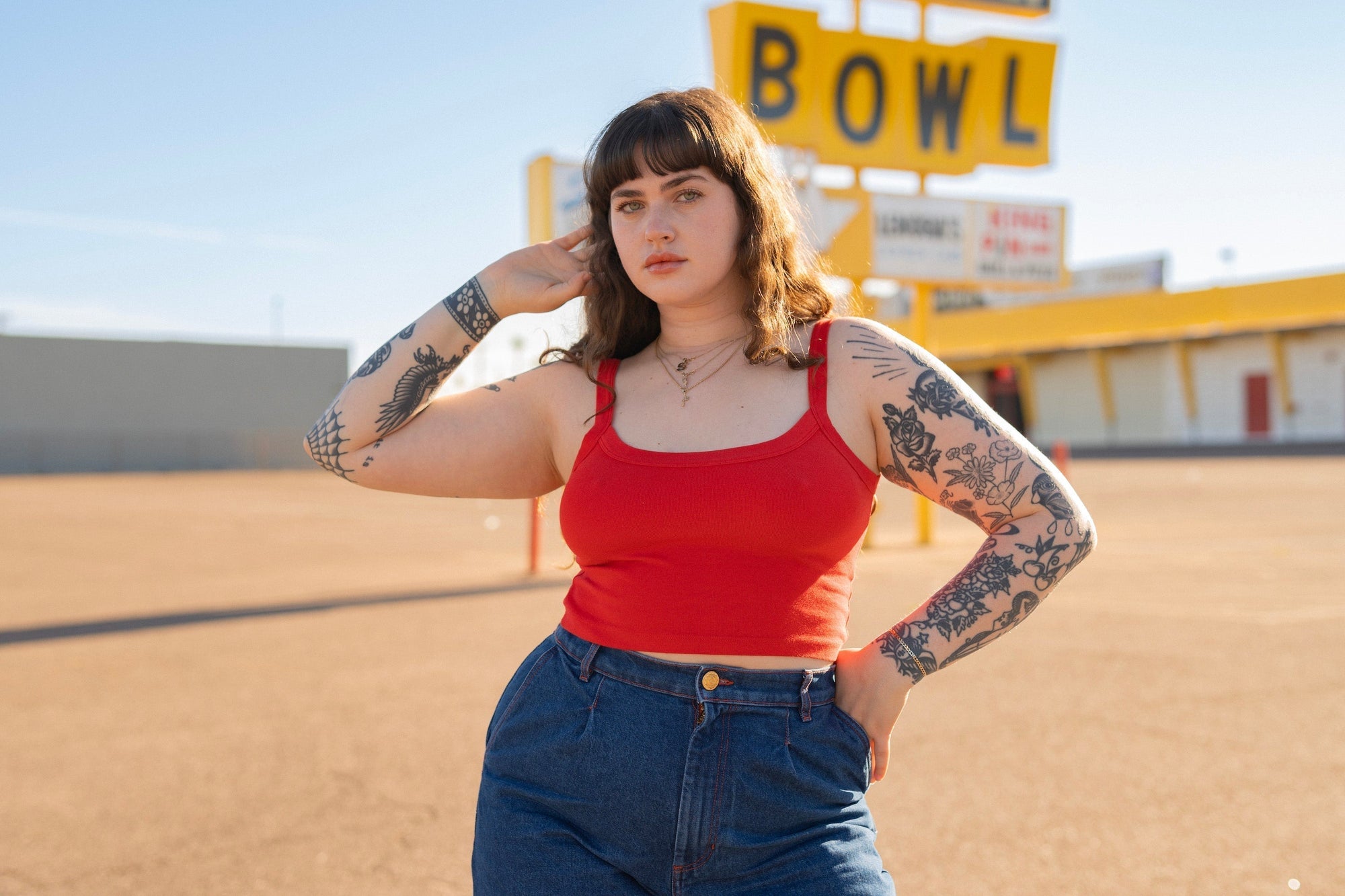 Sydney is wearing Cropped Cami in Mustang Red and Indigo Wide Leg Trousers in Dark Wash