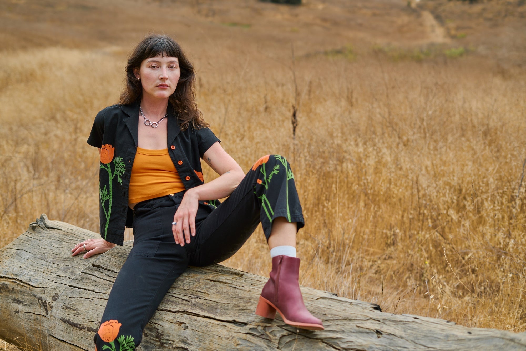 Alexandra Skye is wearing Paintstamped Pantry Button-Up in Poppy with matching Work Pants. Cropped Tank in Creamsicle Orange underneath