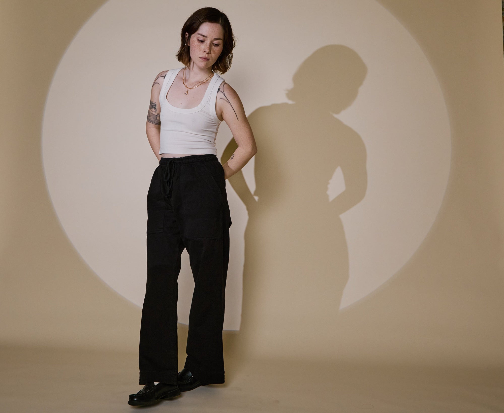 Hana is wearing Organic Action Pants in Basic Black and Cropped Tank Top in Vintage Tee White