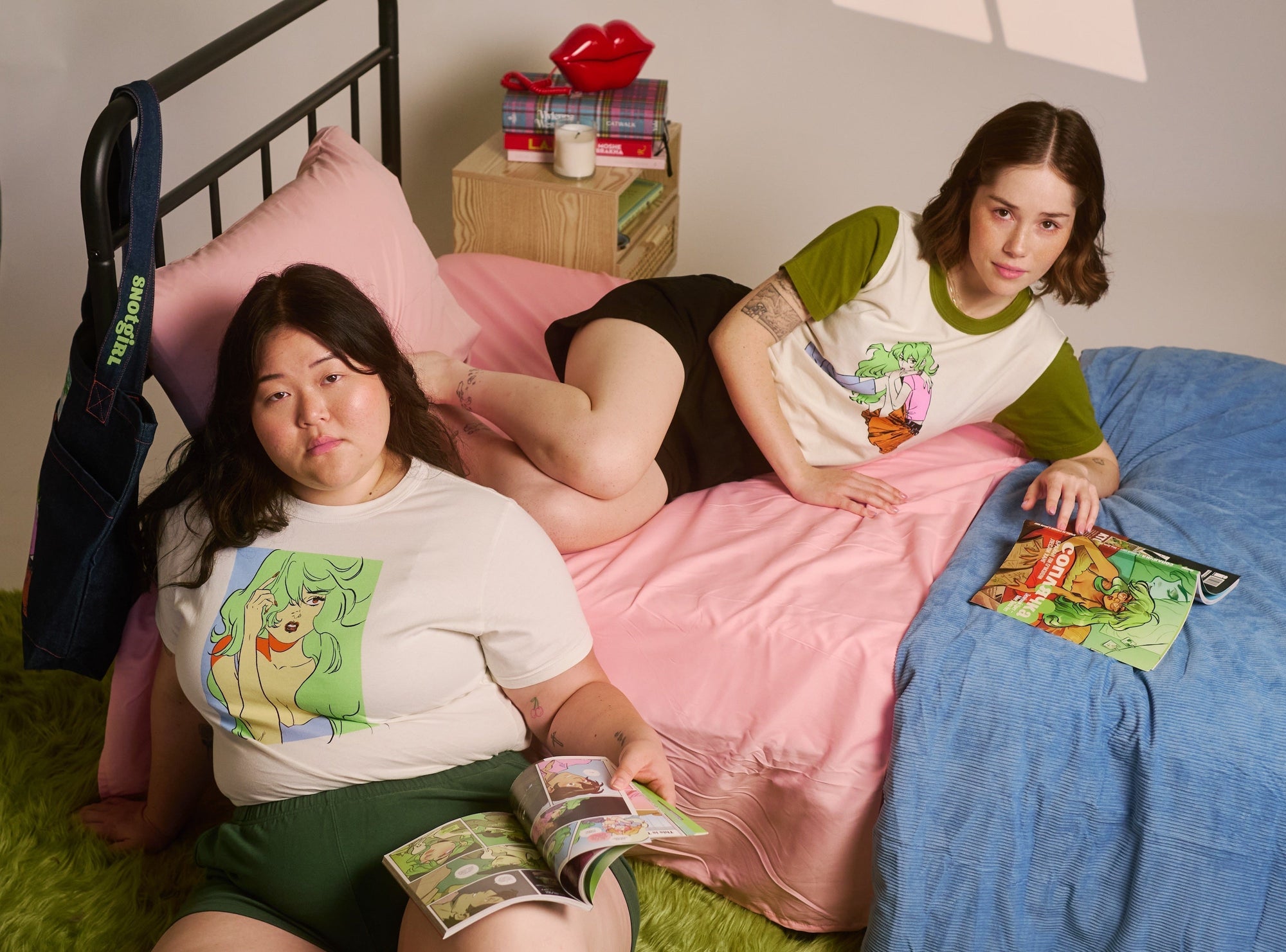 Ashley is wearing the Snotgirl Comic Tee paired with Easy Shorts in Dark Emerald Green. Hana is wearing the Olive Lottie Tee and Easy Shorts in Black