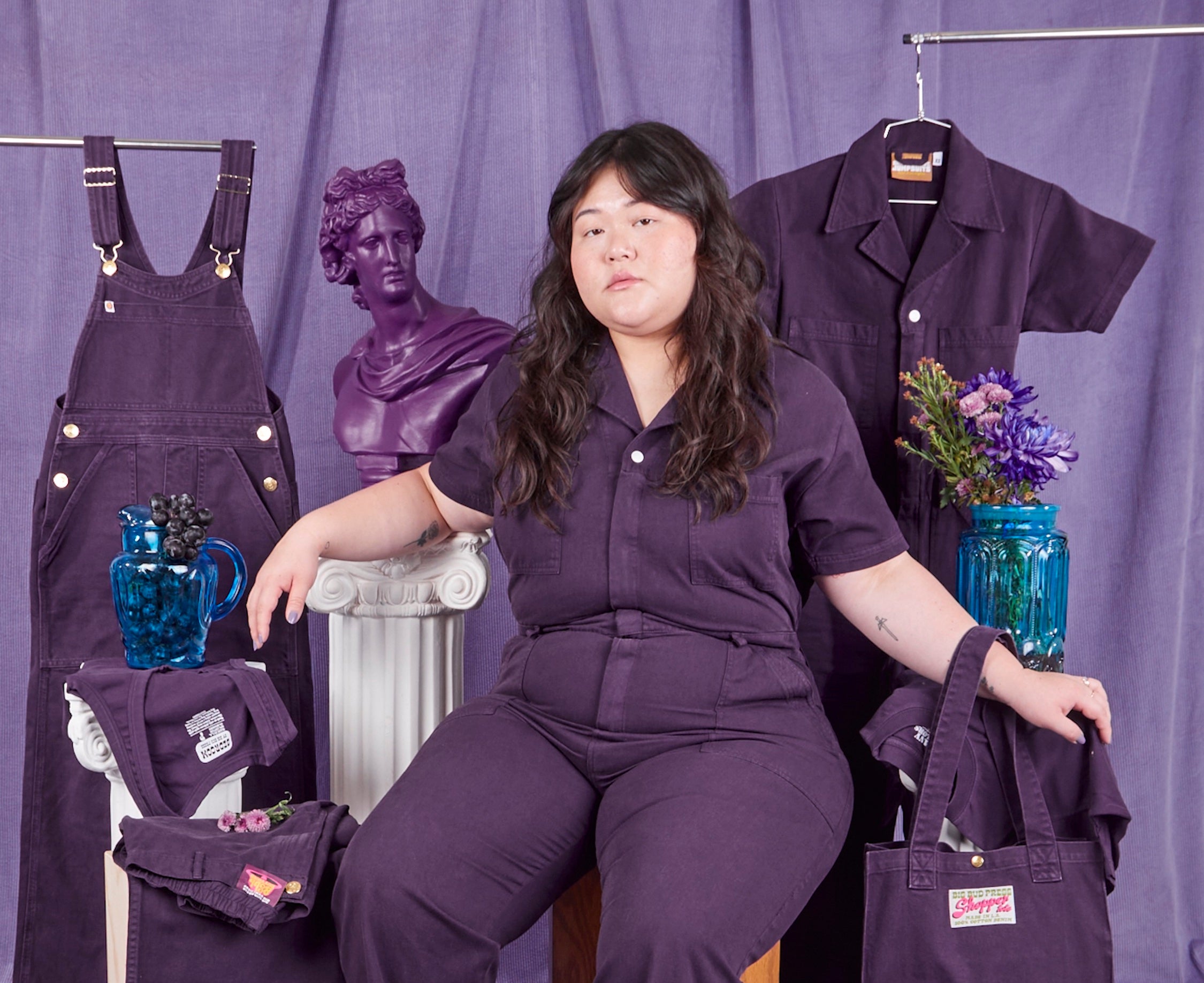 Ashley is wearing a Short Sleeve Jumpsuit in Nebula. Items from the Nebula collection surround Ashley