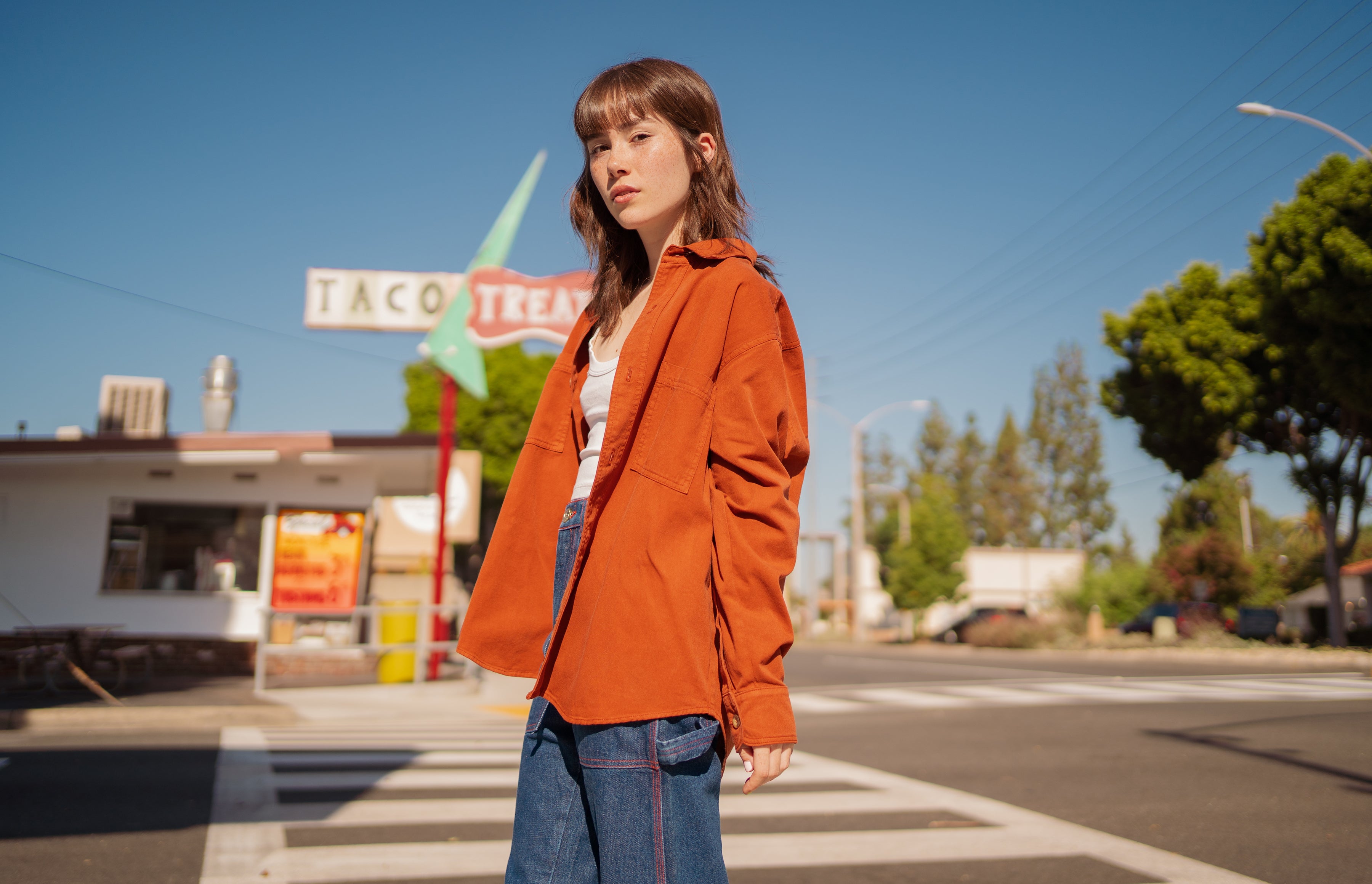 Hana is wearing Oversize Overshirt in Burnt Terracotta, Cropped Tank Top in Vintage Off-White and Carpenter Jeans in Dark Denim