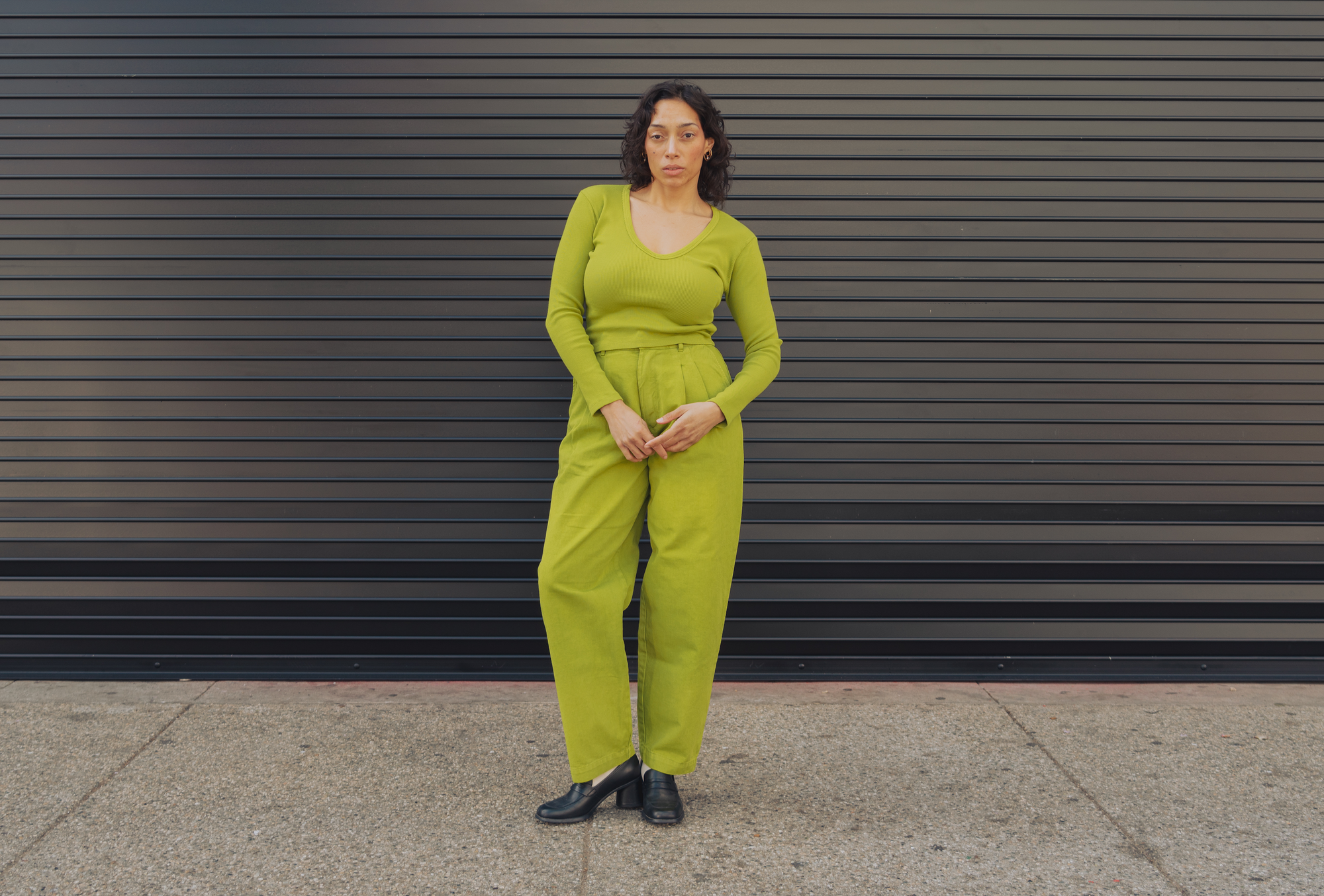Tiara is wearing Long Sleeve V-Neck Tee in Gross Green and Heavyweight Trousers in Gross Green