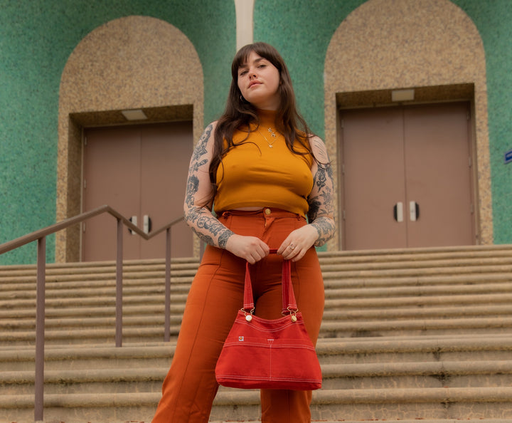 Sydney is wearing Sleeveless Essential Turtleneck in Spicy Mustard, Western Pants in Burnt Terracotta, and Overall Handbag in Paprika