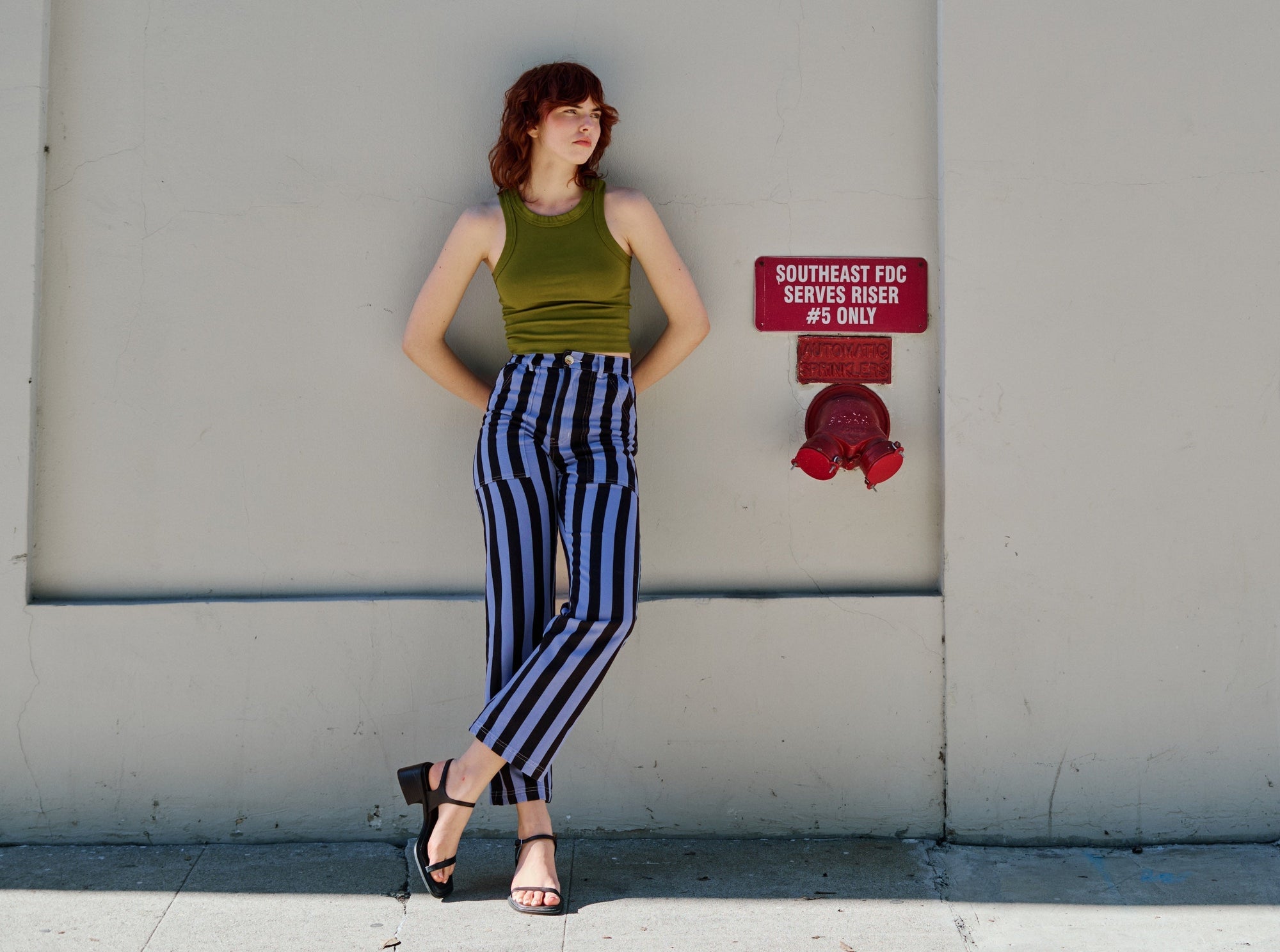 Brooke is wearing Racerback Tank in Summer Olive and Black Stripe Work Pants in Cornflower Blue