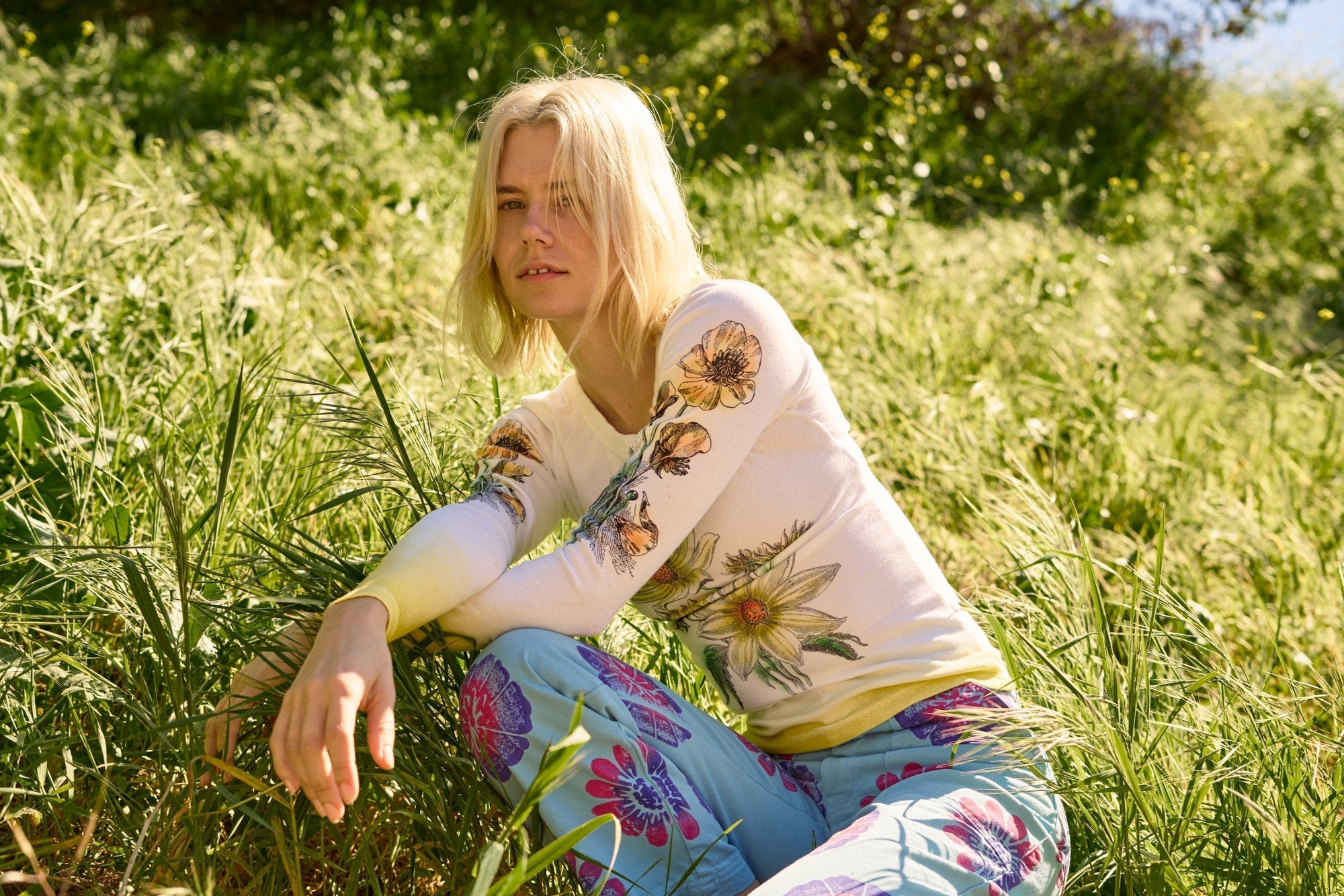 Madeline is wearing Floral Long Sleeve Baby Tee in Yellow and Floral Painted Work Pants in Blu