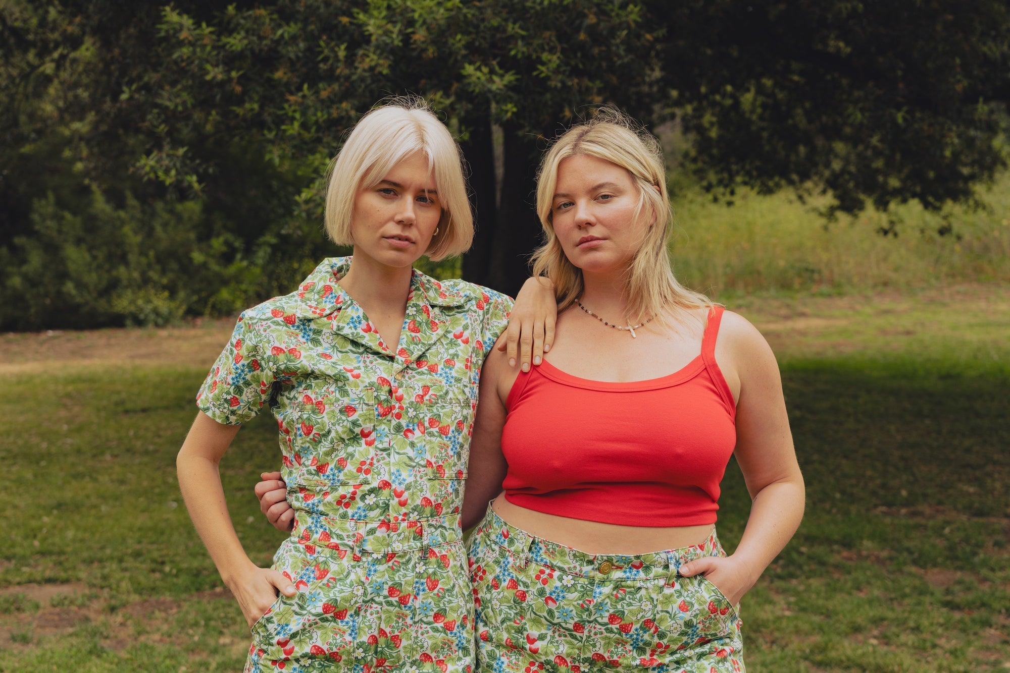 Lish is wearing Work Pants in Strawberry Blossom and a mustang red Cami. Madeline is wearing a Short Sleeve Jumpsuit in Strawberry Blossom