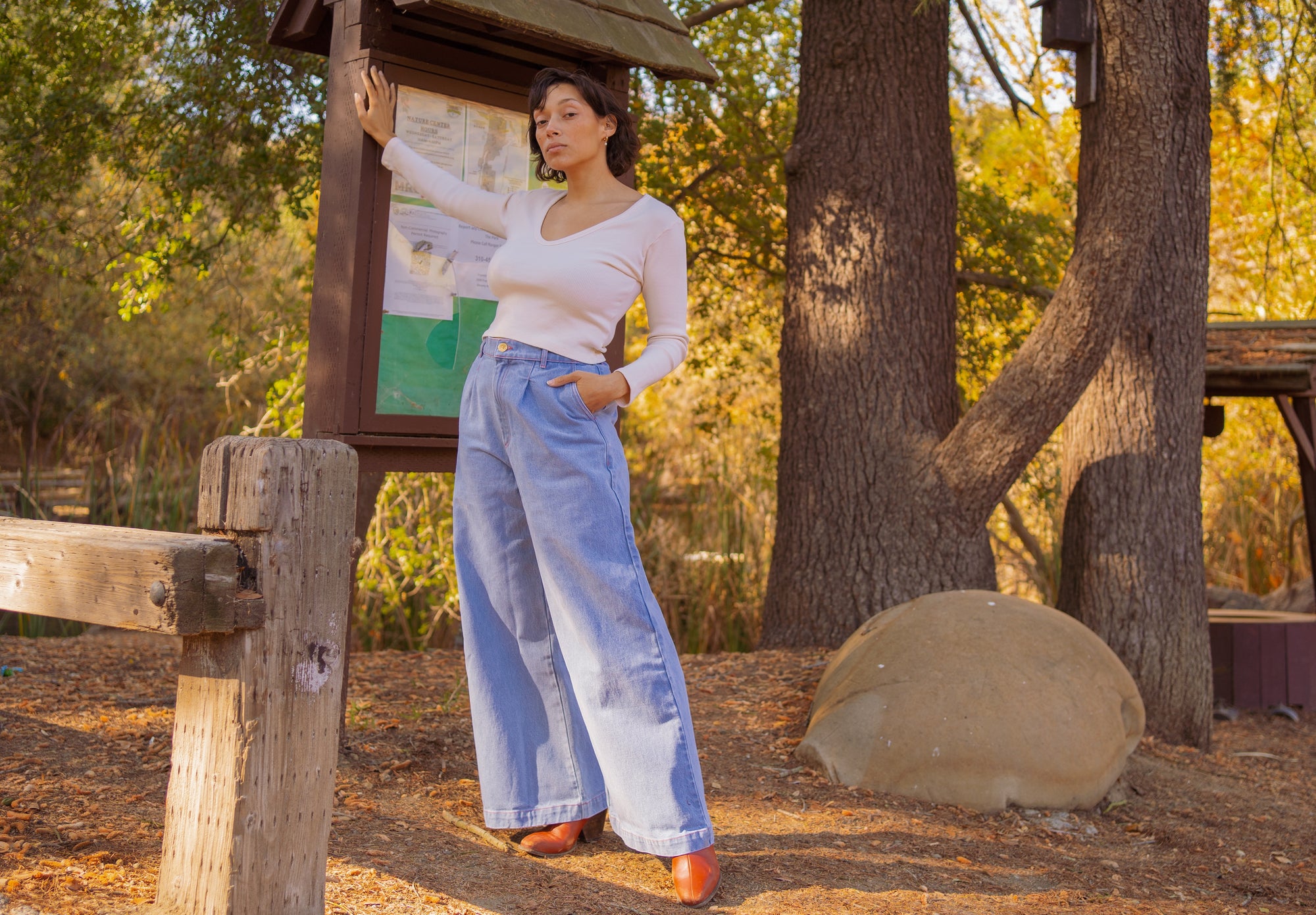 Tiara is wearing Indigo Wide Leg Trousers in Light Wash and Long Sleeve V-Neck Tee in Vintage Off-White