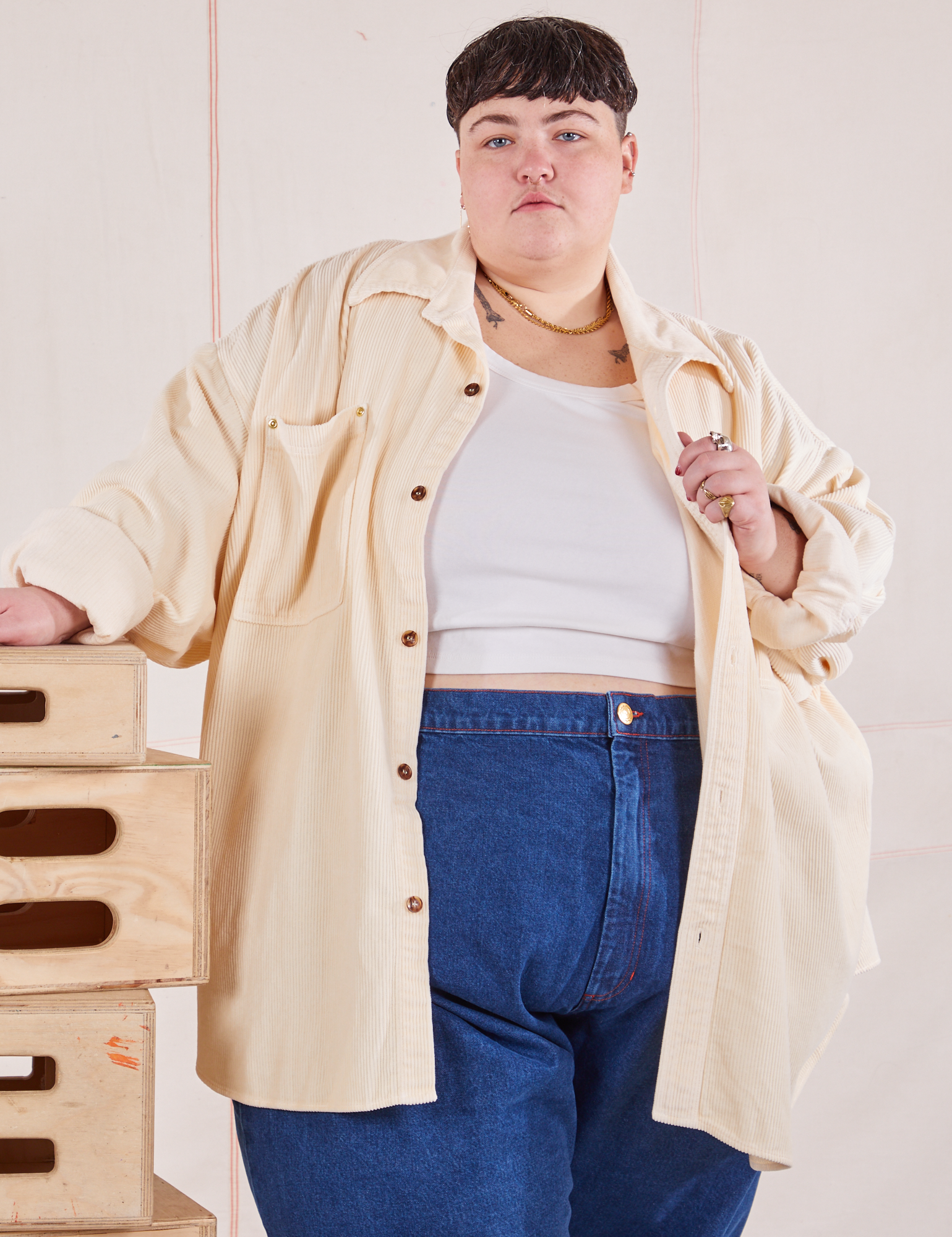 Jordan is 5'4" and wearing 4XL Corduroy Overshirt in Vintage Off-White with a vintage off-white Cropped Tank Tp underneath and dark wash Trouser Jeans
