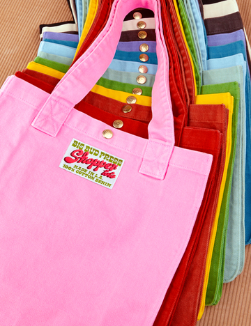 Shopper Tote Bag stacked on top of one another in a rainbow of hues