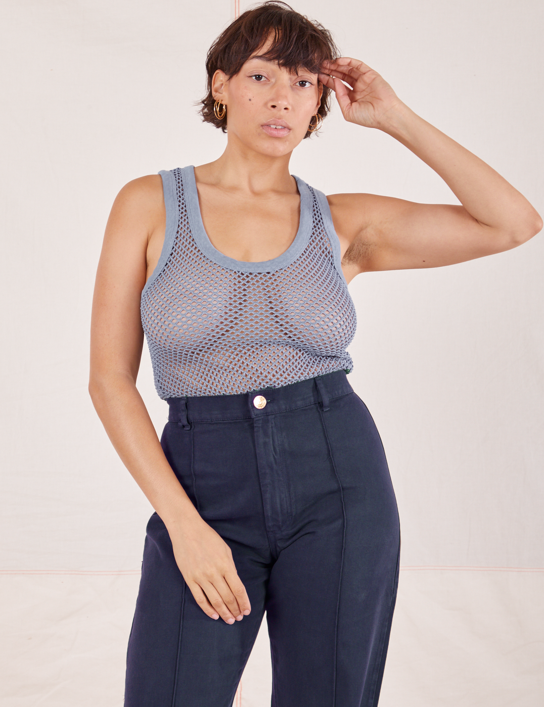 Tiara is 5'4" and wearing XS Mesh Tank Top in Periwinkle paired with navy Western Pants