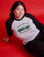 Ashley is wearing a Taxi Raglan Tee in Los Angeles. White body with black sleeves.
