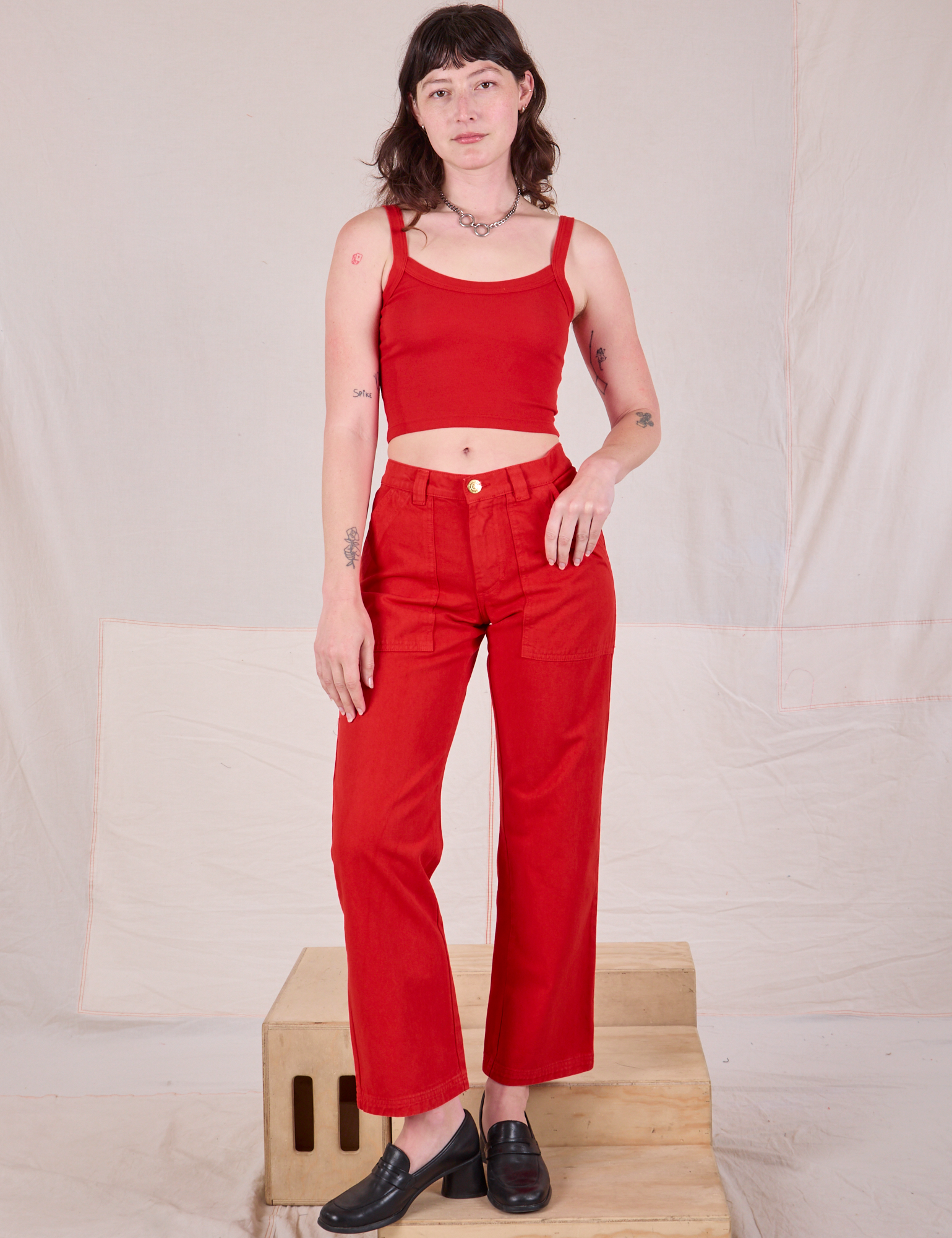 Alex is 5’8” and wearing XXS Mid-Rise Work Pants in Mustang Red paired with matching Cropped Cami