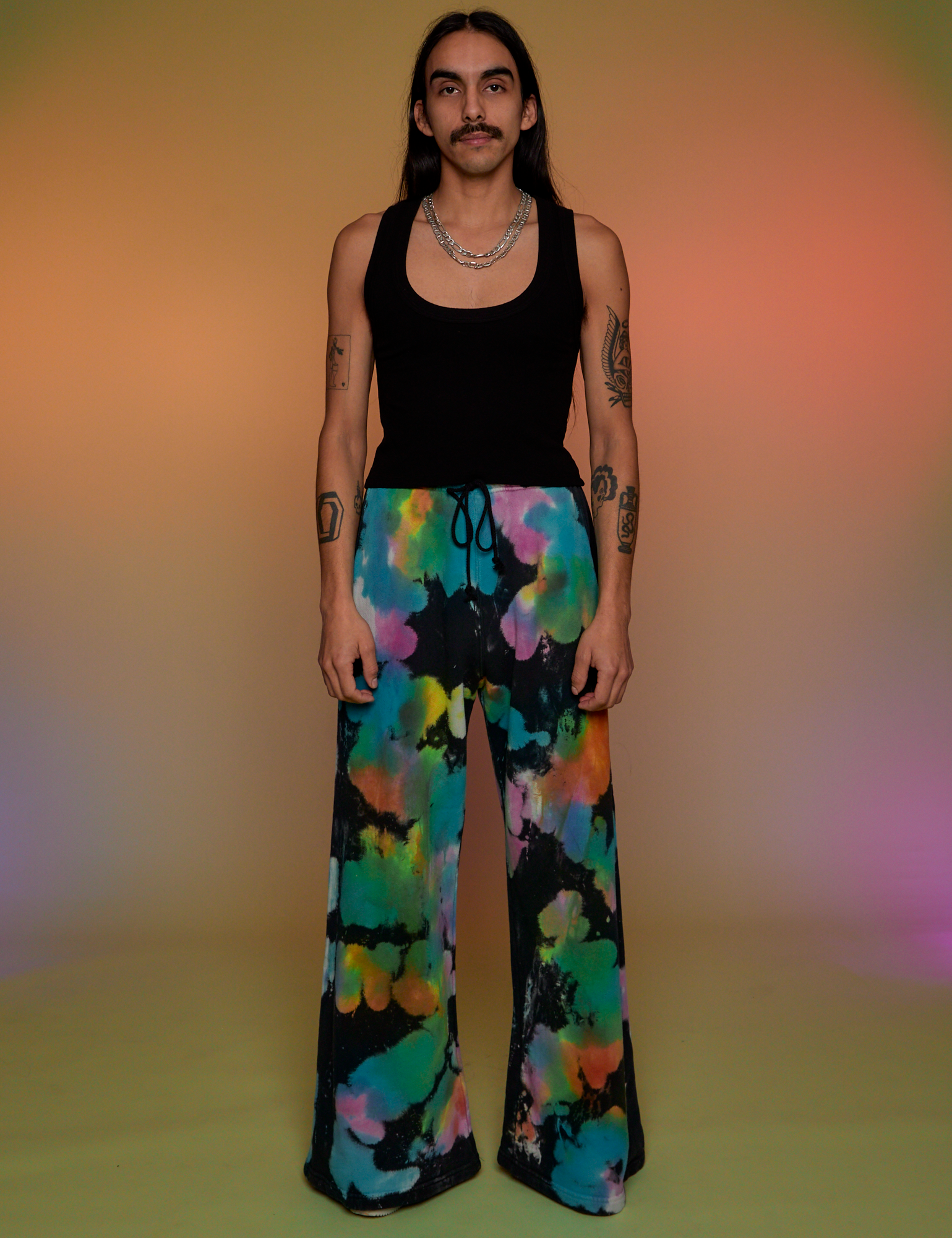 Anthony is 5’6” and wearing S Tie Dyed Wide Leg Sweat Pants paired with black Tank Top