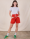 Alex is 5'8" and wearing XXS Sweat Shorts in Mustang Red paired with Jr. Varsity Tee in Stone White