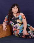 Ashley is wearing Petite Short Sleeve Jumpsuit in Rainbow Magic Waters