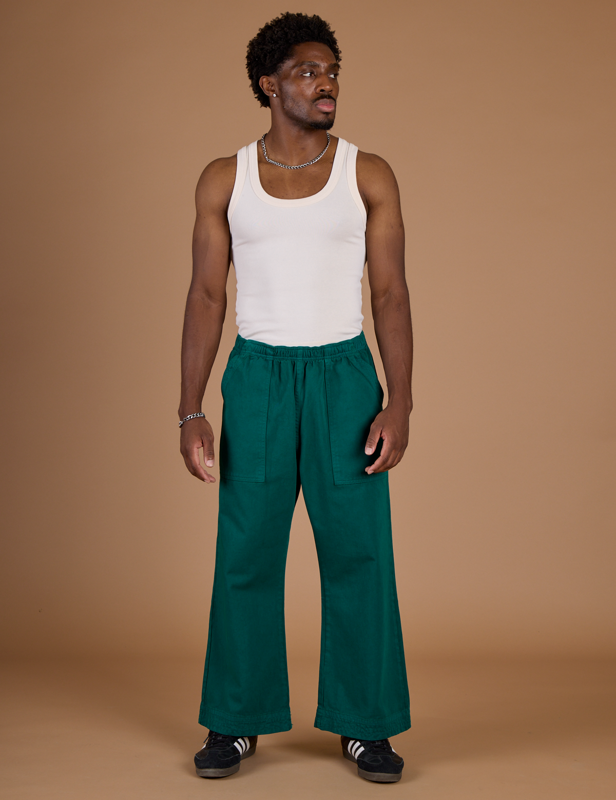 Isaac is 5'10" and wearing M Hunter Green Action Pant with the Vintage Tee Off-White Tank Top