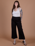 Sydney is 5’9” and wearing M Action Pants in Basic Black paired with Cropped Tank in Vintage Tee White
