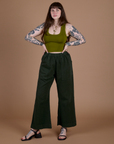 Sydney is 5’9” and wearing M Action Pants in Swamp Green paired with olive green Cropped Tank
