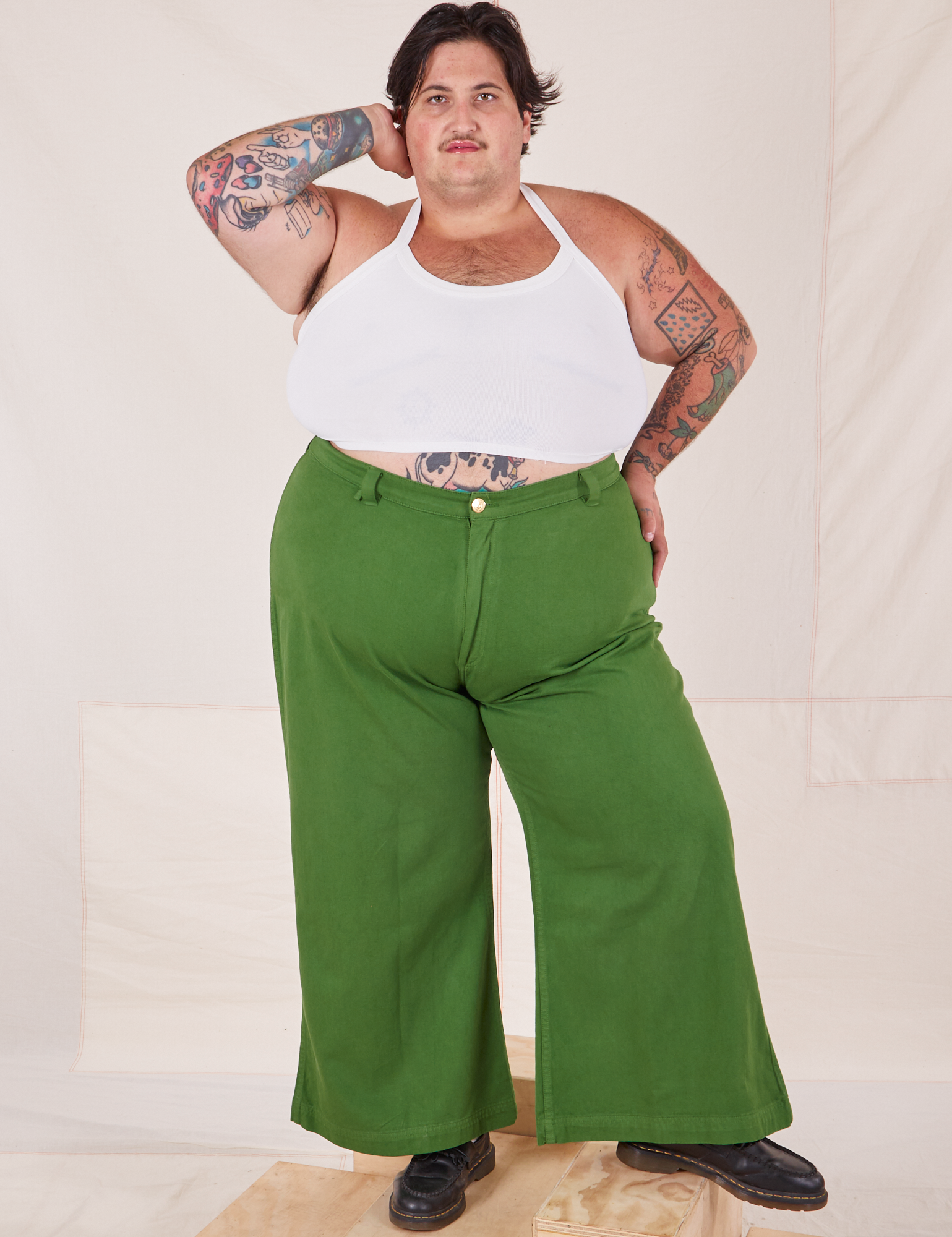 Sam is 5'10" and wearing 3XL Bell Bottoms in Lawn Green paired with vintage off-white Halter Top