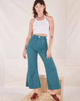 Alex is 5'8" and wearing XXS Bell Bottoms in Marine Blue paired with vintage off-white Halter Top