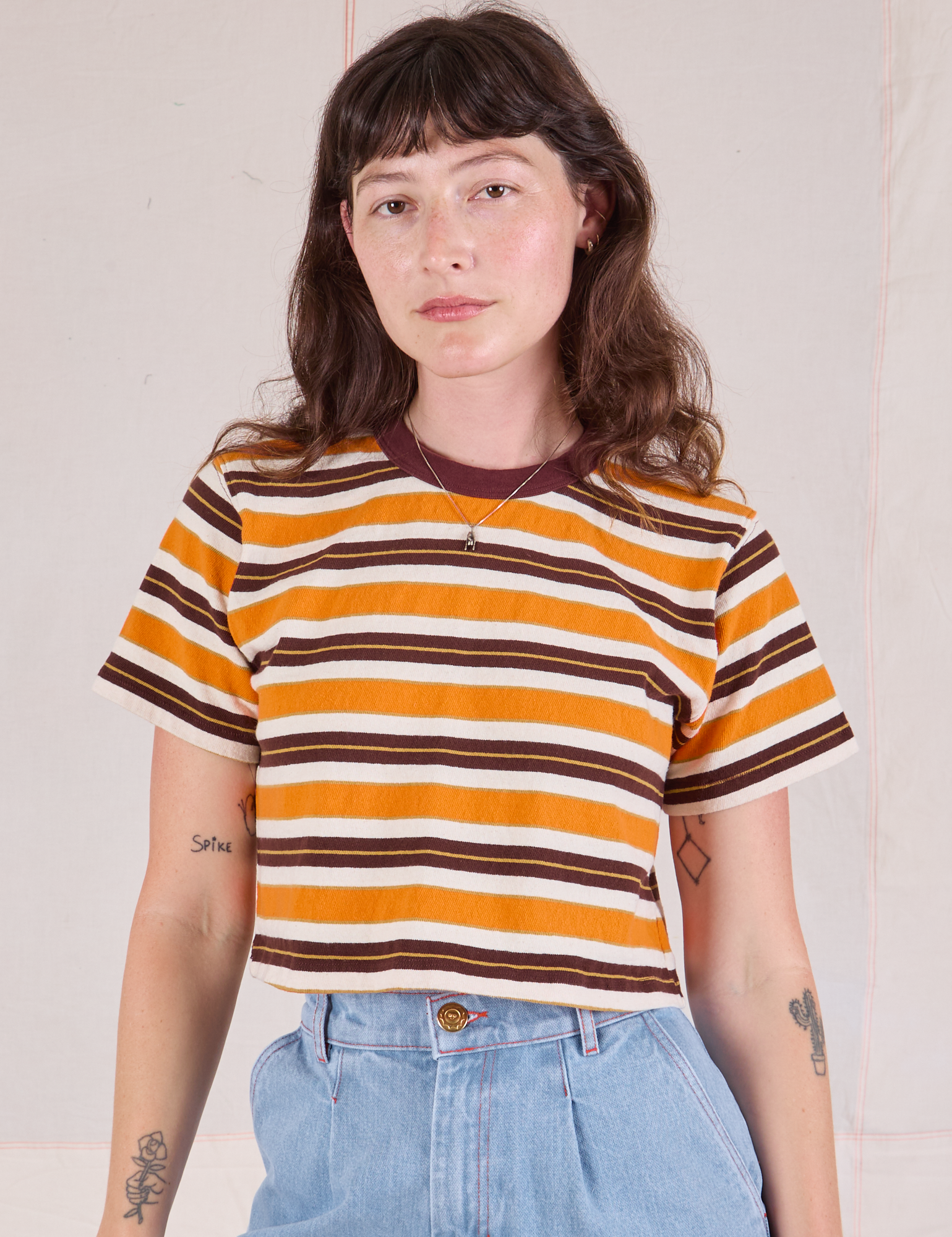 Alex is 5'8" and wearing P Striped Crop Burly Tee in Orange & Brown