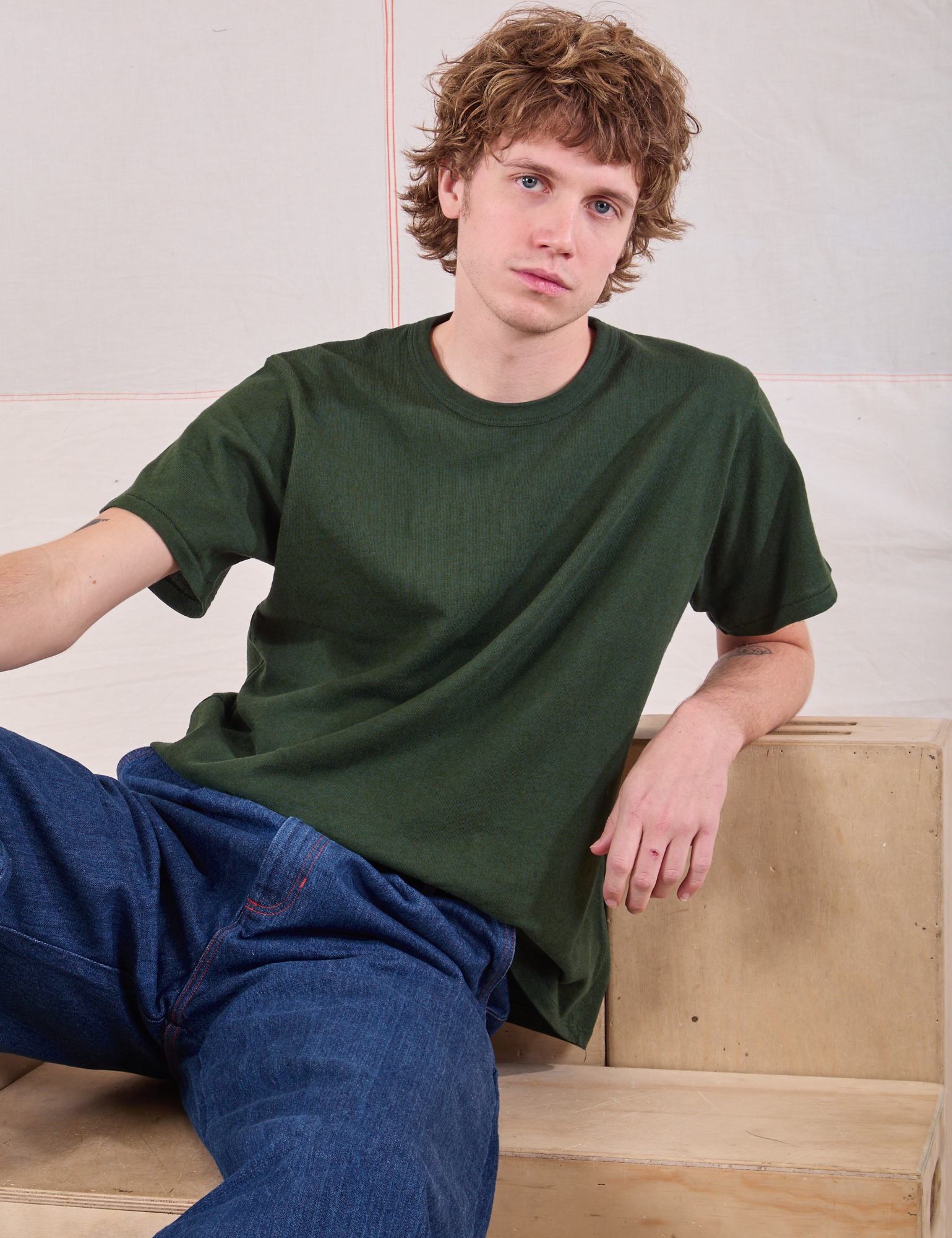 Quinn is wearing Burly Tee in Swamp Green