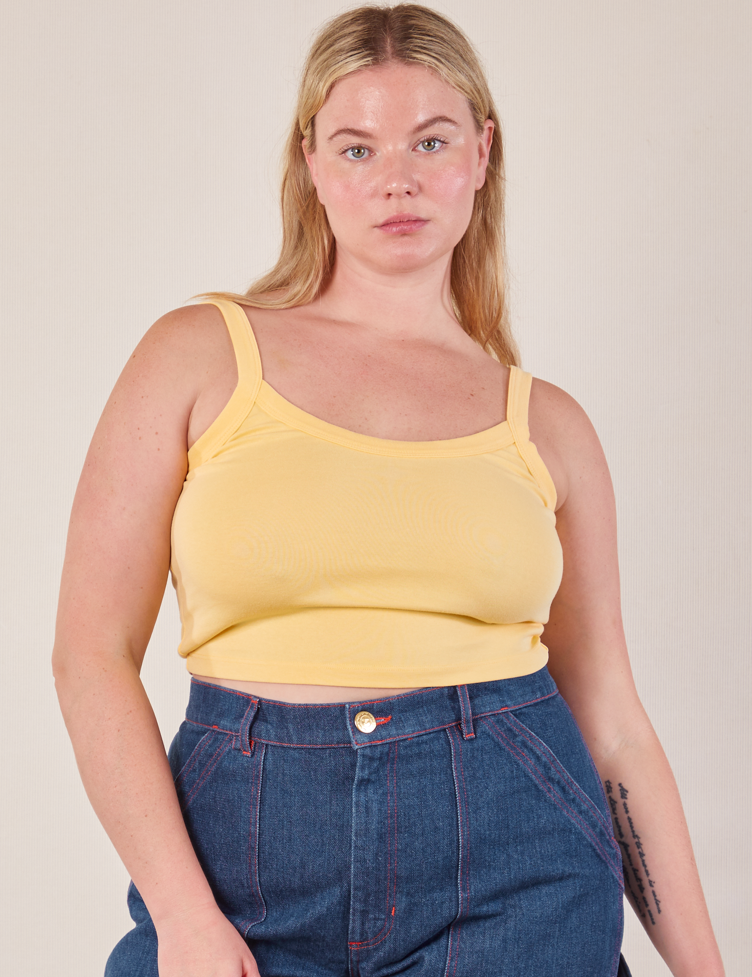 Lish is 5’8” and wearing M Cropped Cami in Butter Yellow paired with dark wash Carpenter Jeans