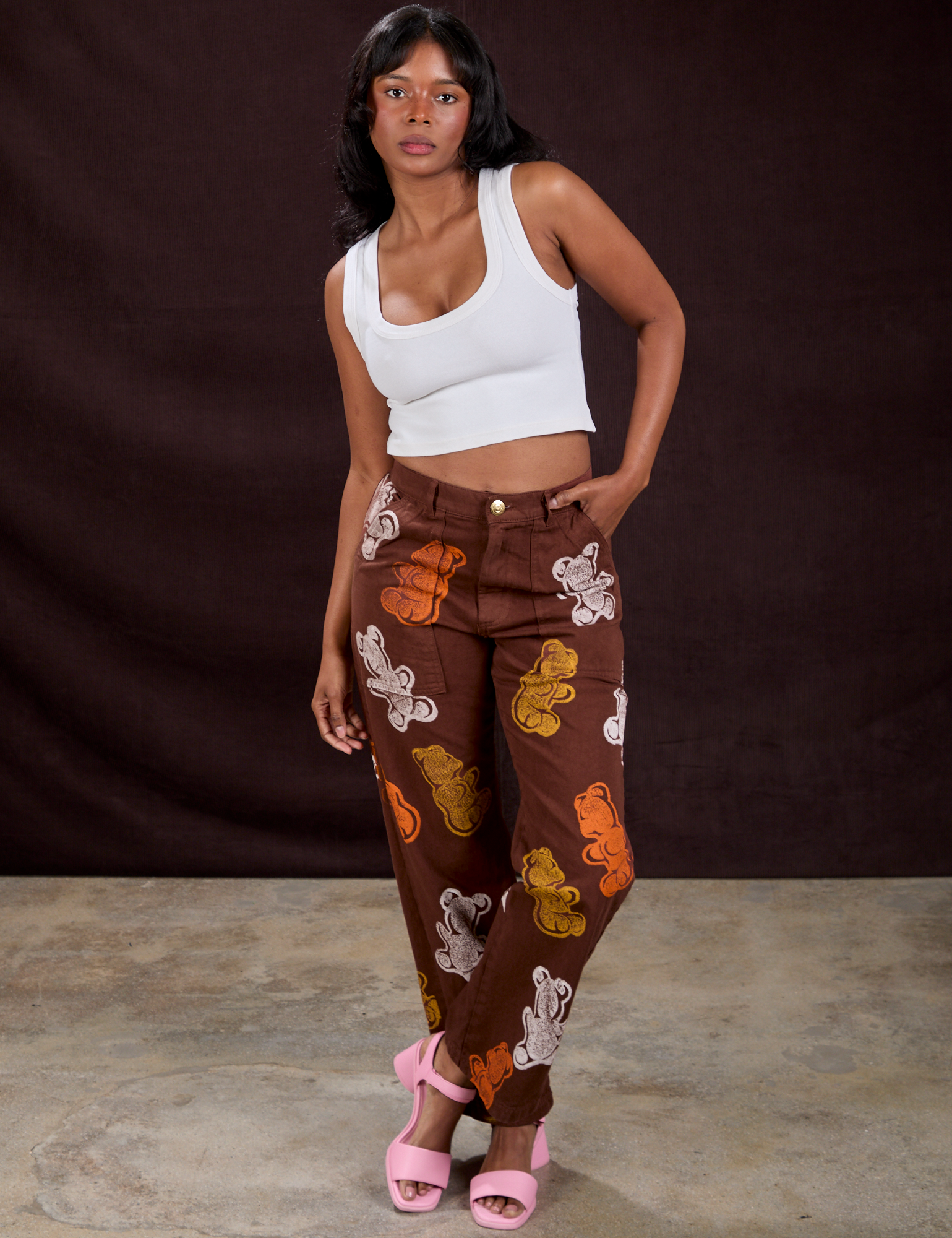 Kandia is 5'3" and wearing XS Gummy Bear Paintstamped Work Pants in Fudgesicle Brown paired with a Cropped Tank in Vintage Tee White