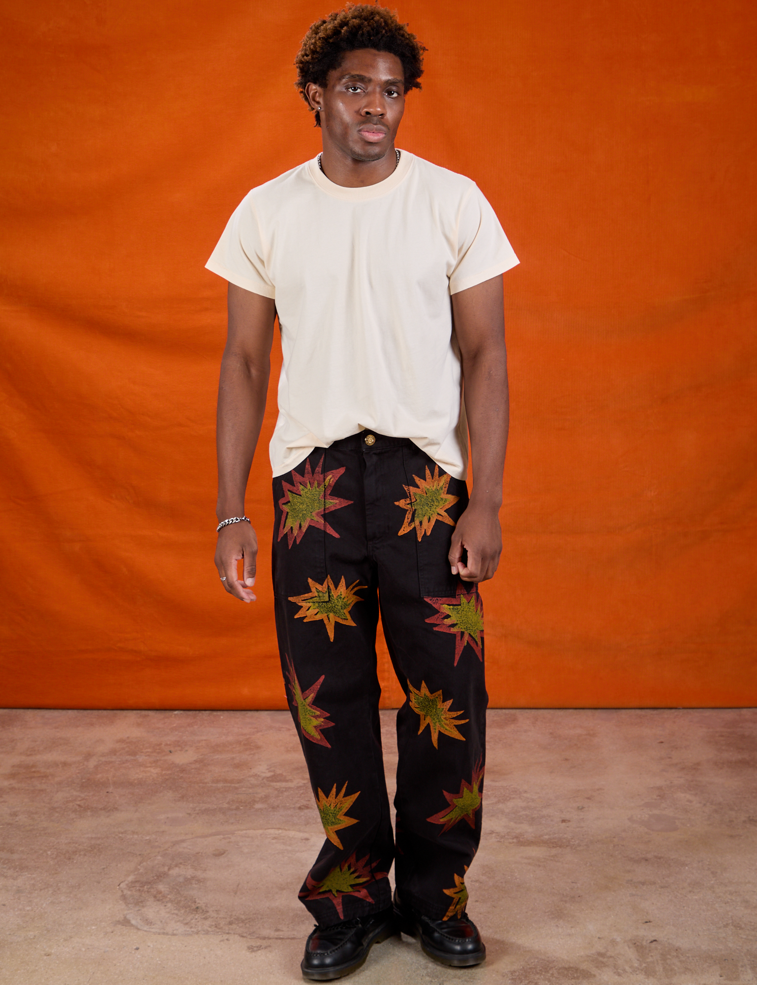 Isaac is 5'10" and wearing M Paintstamped Work Pants in Explosion paired with Organic Vintage Tee in Vintage Off-White