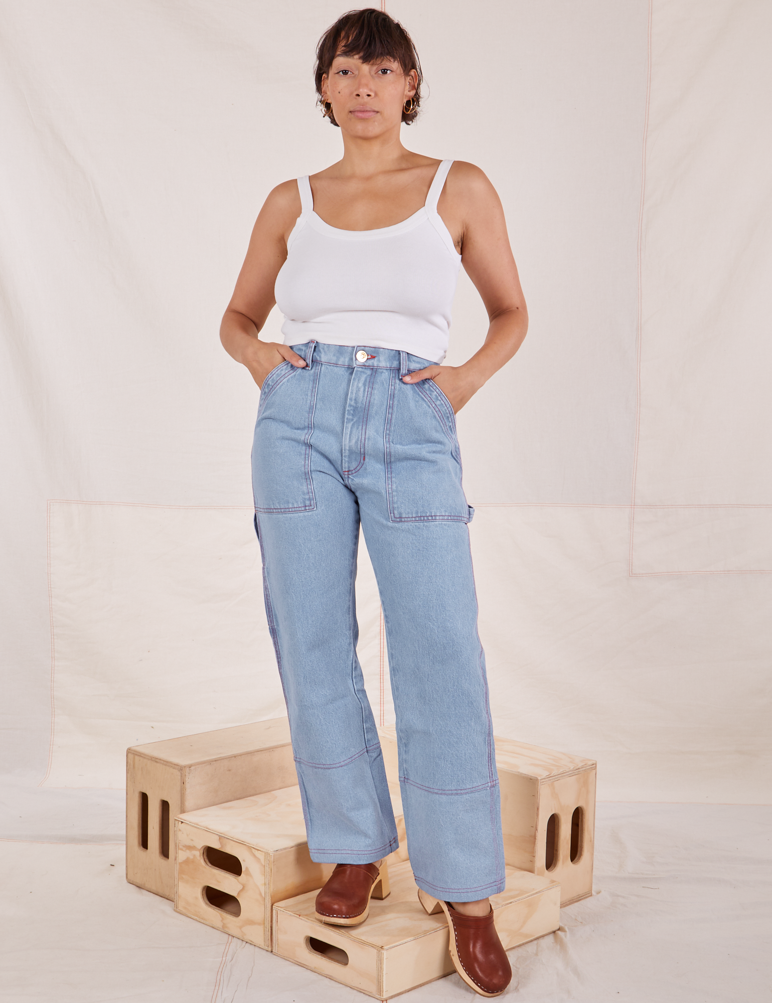 Tiara is 5&#39;4&quot; and wearing S Carpenter Jeans in Light Wash paired with vintage off-white Cami