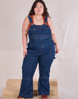 Ashley is 5'7" and wearing 1XL Carpenter Overalls in Dark Wash