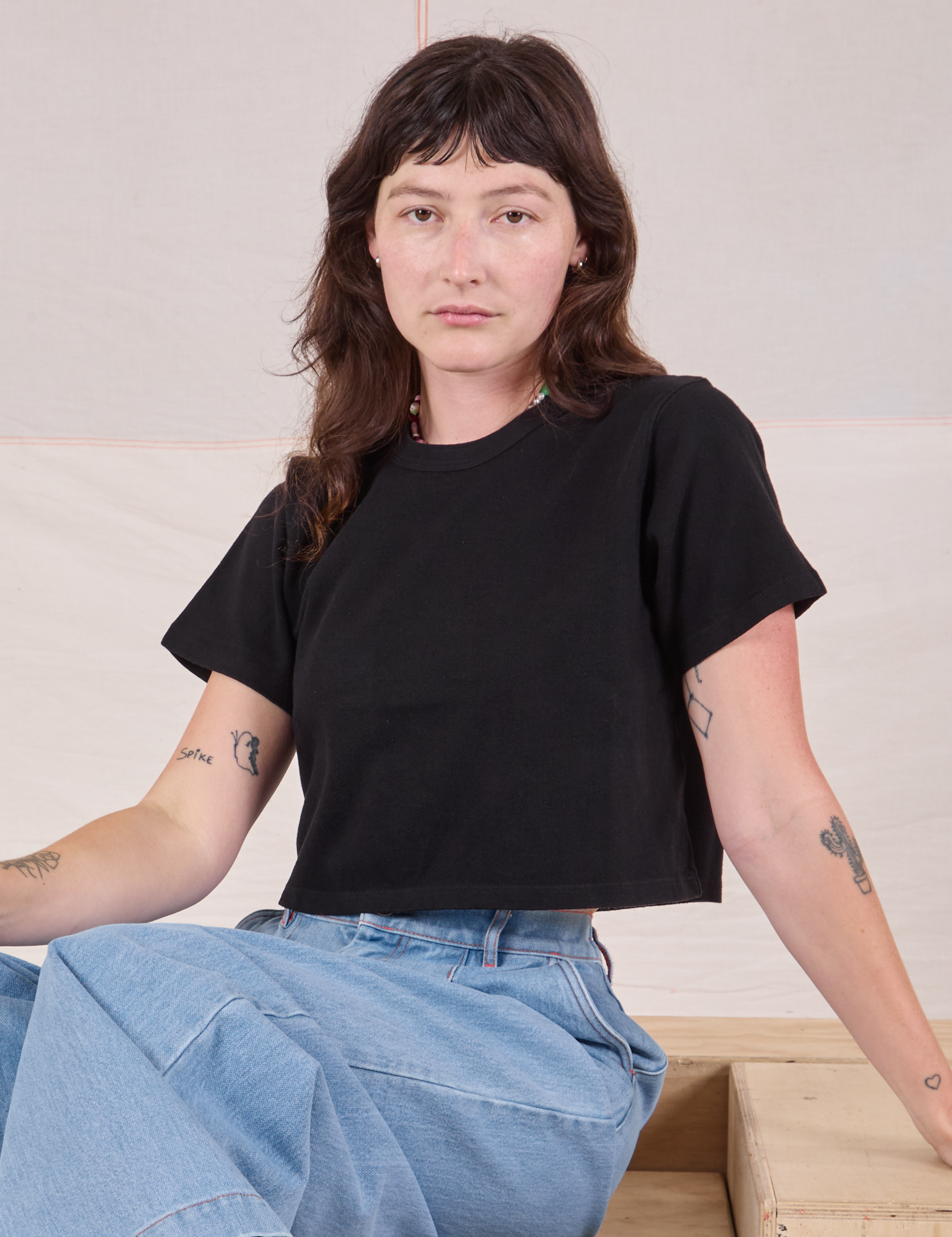Alex is 5'8" and wearing P Cropped Burly Tee in Basic Black
