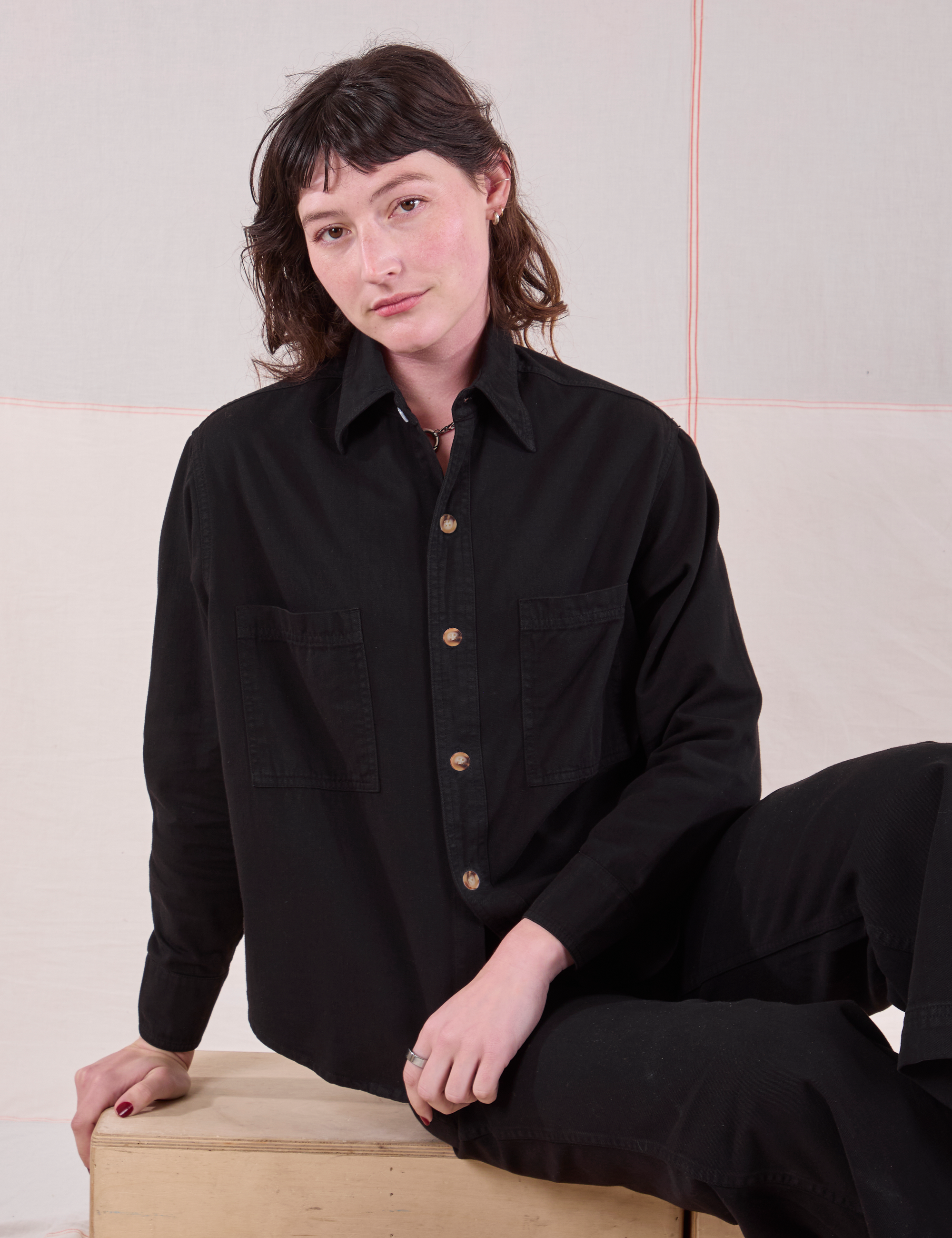 Alex is wearing a buttoned up Cropped Overshirt in Basic Black