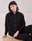 Alex is wearing a buttoned up Cropped Overshirt in Basic Black