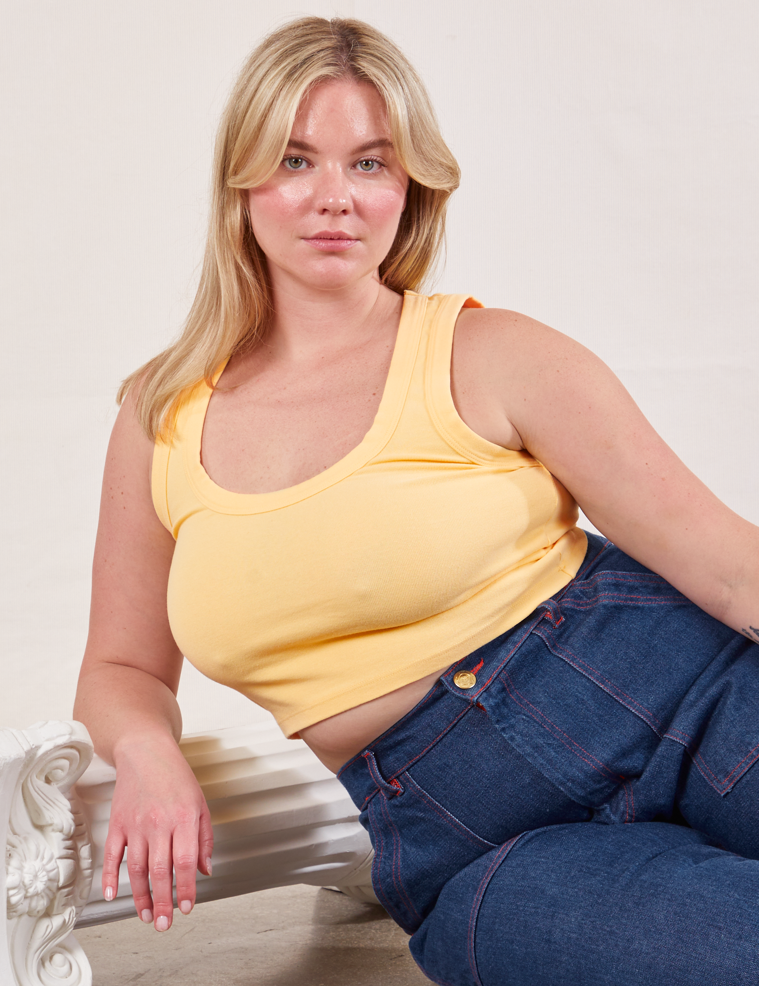 Lish is wearing Cropped Tank Top in Butter Yellow and dark wash Carpenter Jeans