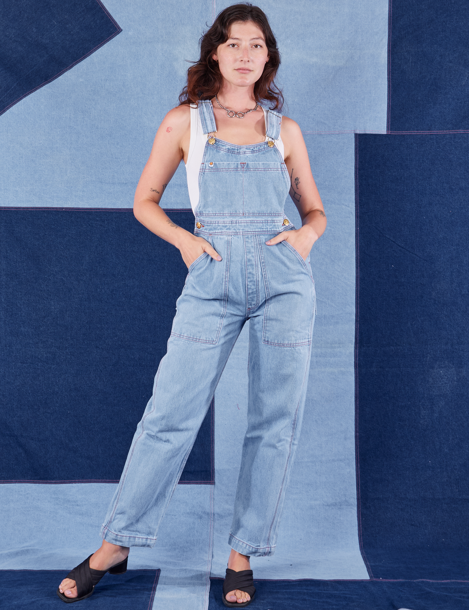 Alex is 5&#39;8&quot;and wearing P Indigo Denim Original Overalls in Light Wash